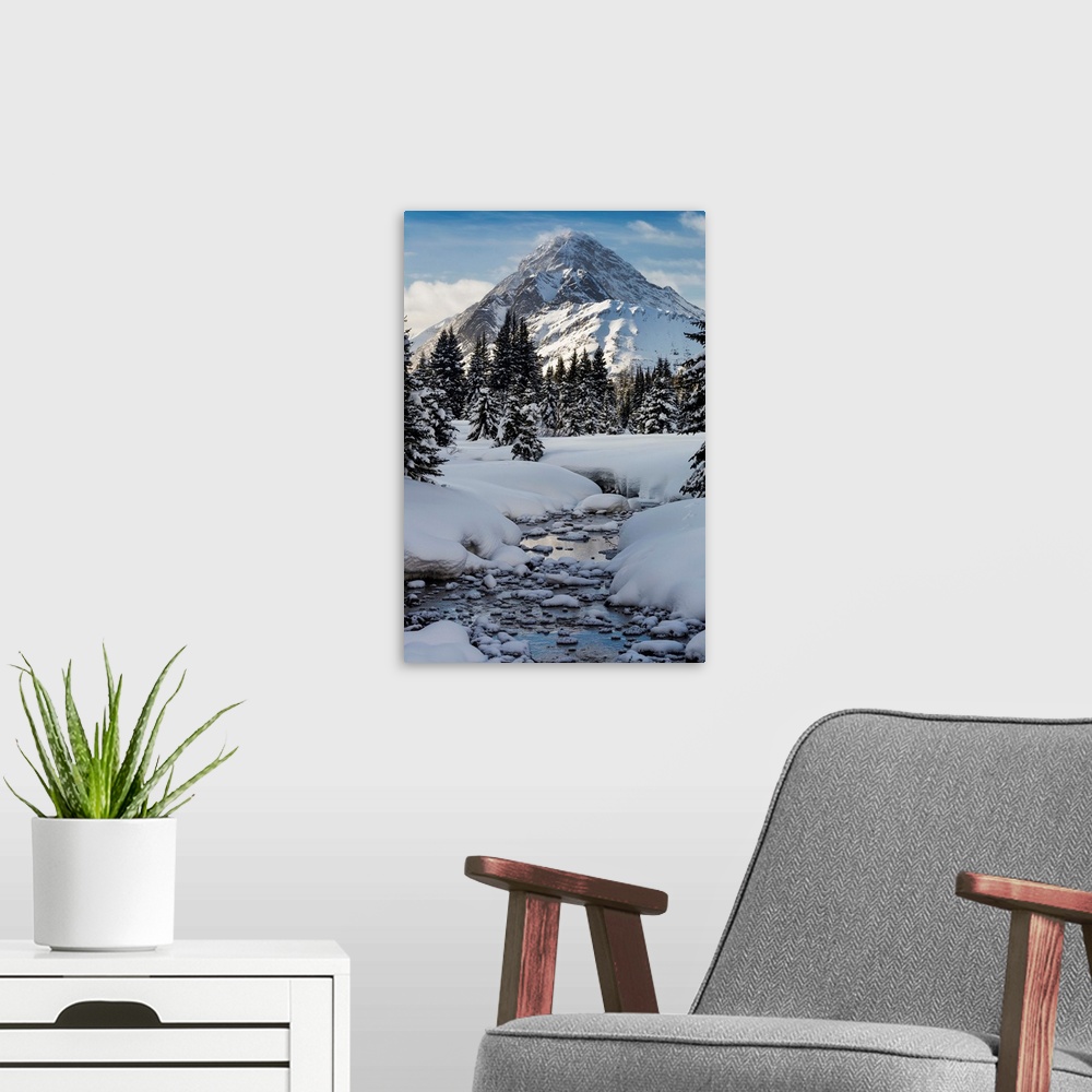 A modern room featuring An open creek with snow covered curvy banks, filled with snow covered rocks and snow covered tree...