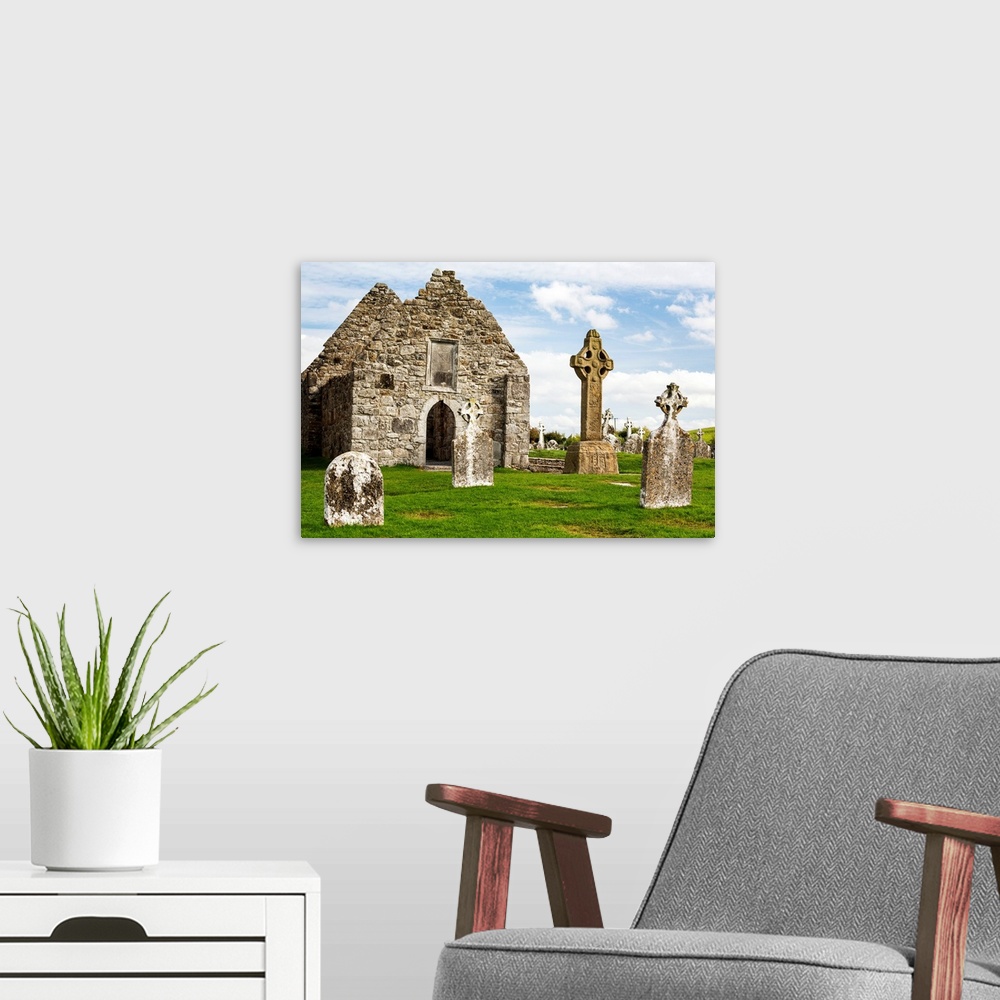 A modern room featuring Ancient stone roofless church with celtic crosses in a grassy field, County Offaly, Ireland.