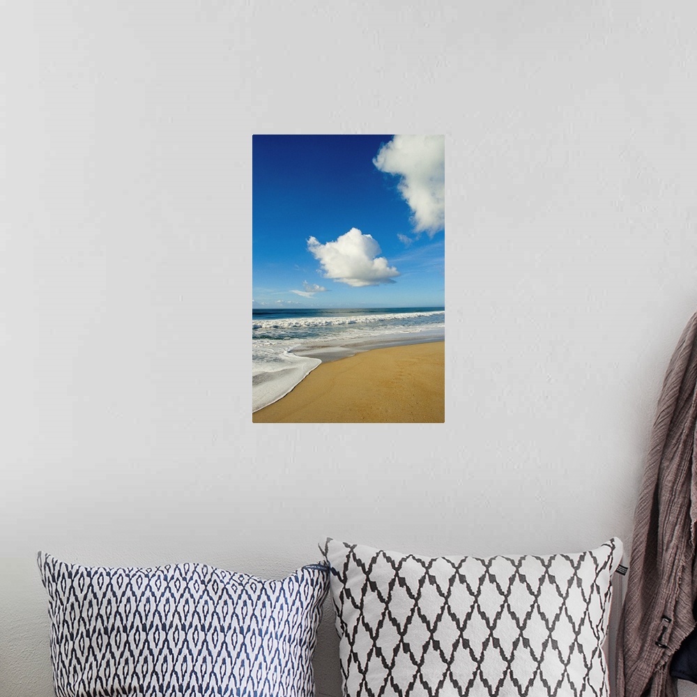 A bohemian room featuring Atlantic ocean waves break on the beach on a sunny day with clouds.