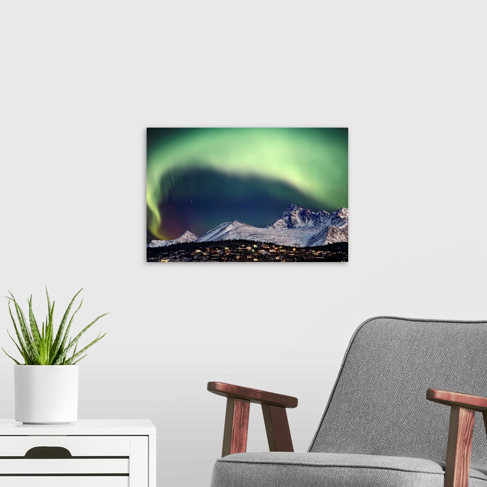 A modern room featuring This aerial natural wonder arches over a snowy mountain top and village captured in a landscape p...