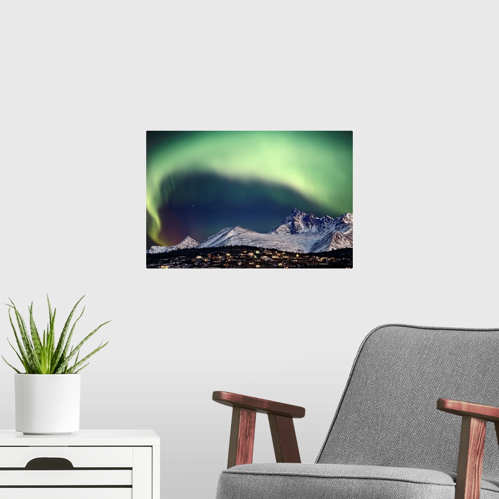 A modern room featuring This aerial natural wonder arches over a snowy mountain top and village captured in a landscape p...