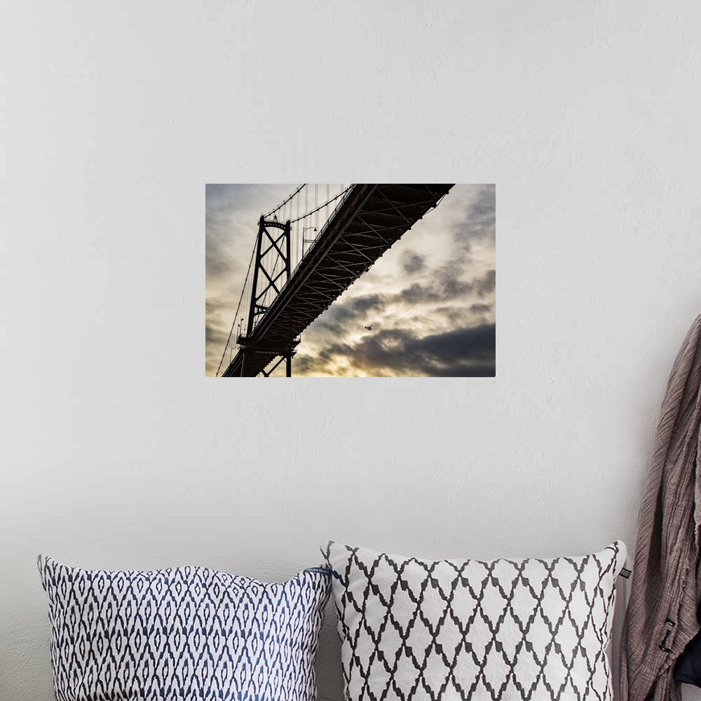 A bohemian room featuring Low angle view of a bridge at sunset with an airplane flying in the distance; Vancouver, British ...
