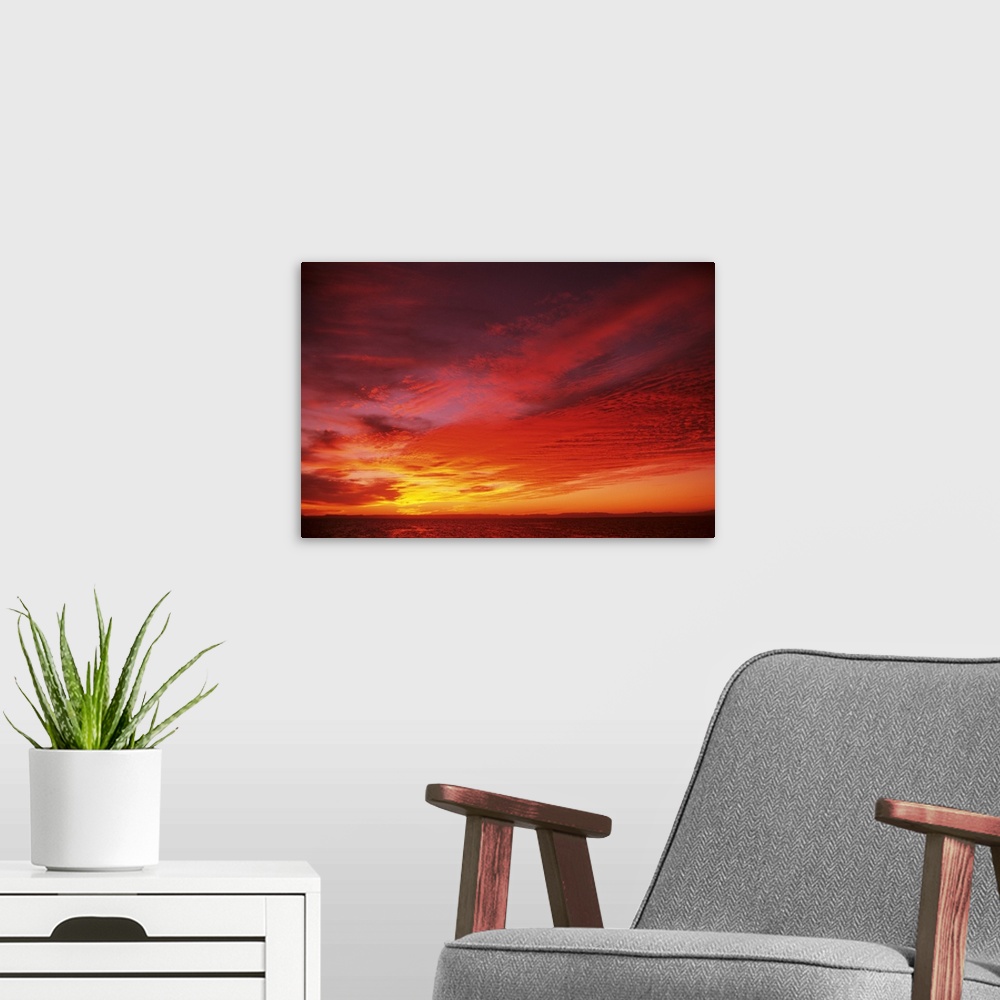 A modern room featuring Bright Orange Sunset Over Ocean
