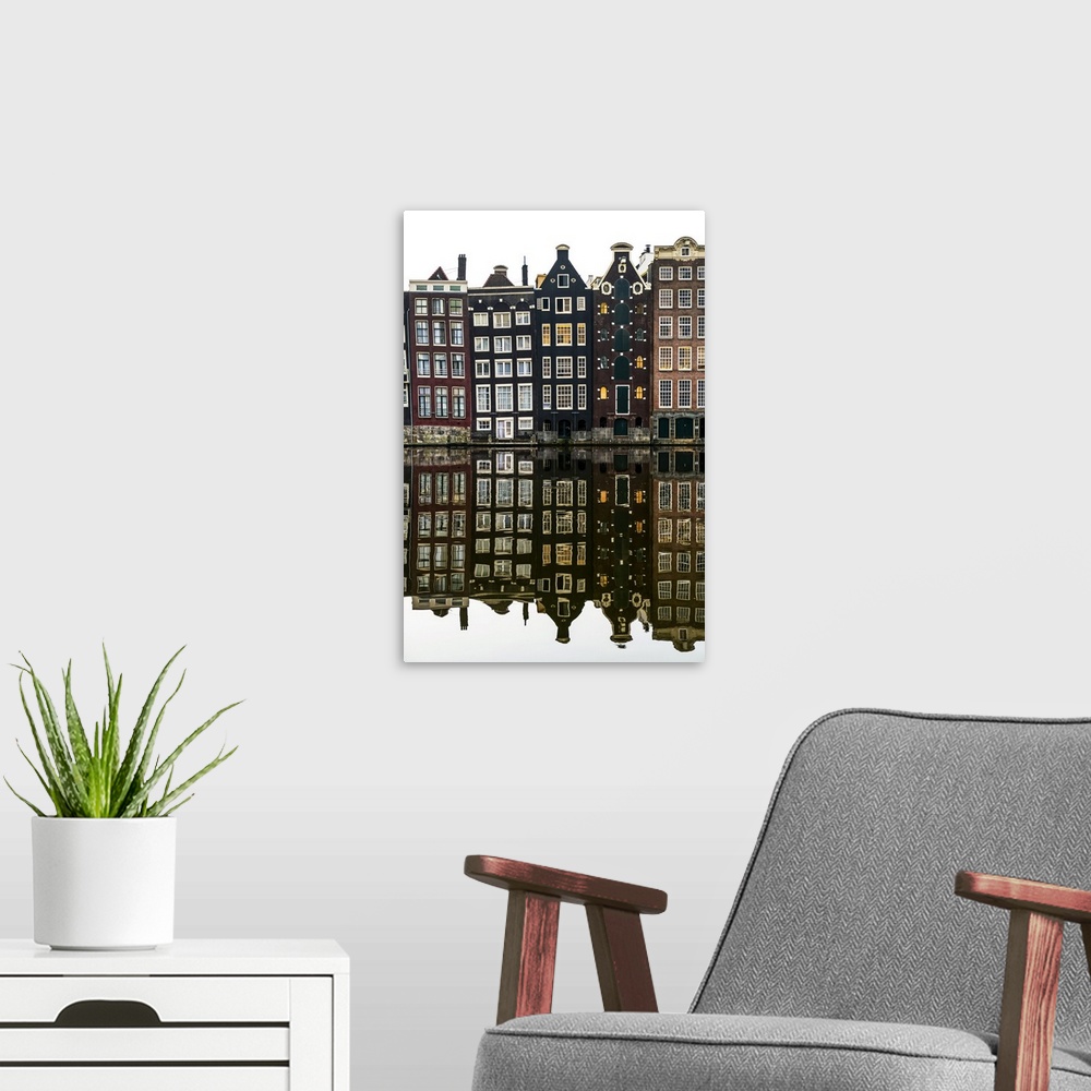 A modern room featuring Building facades with a mirror image reflecting in a canal; Amsterdam, Netherlands