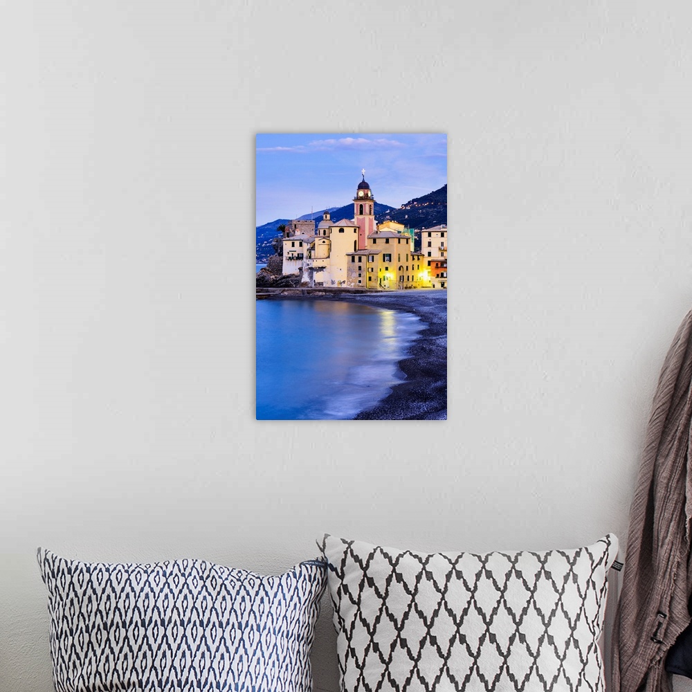 A bohemian room featuring Buildings illuminated by lights along the water's edge at sunrise, Camogli, Liguria, Italy.