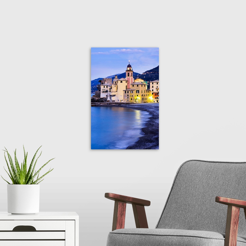 A modern room featuring Buildings illuminated by lights along the water's edge at sunrise, Camogli, Liguria, Italy.