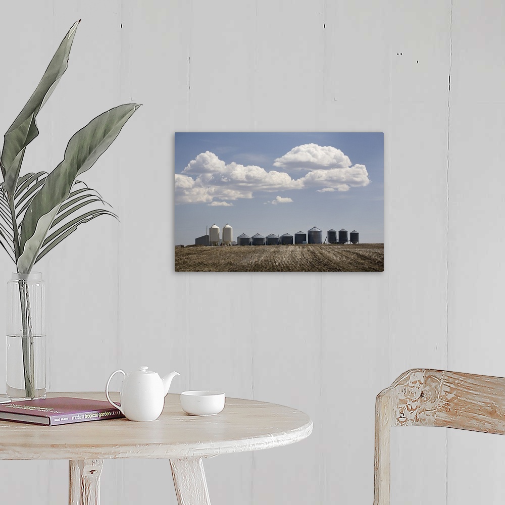 A farmhouse room featuring Calgary, Alberta, Canada; A Row Of Grain Bins In A Tilled Field