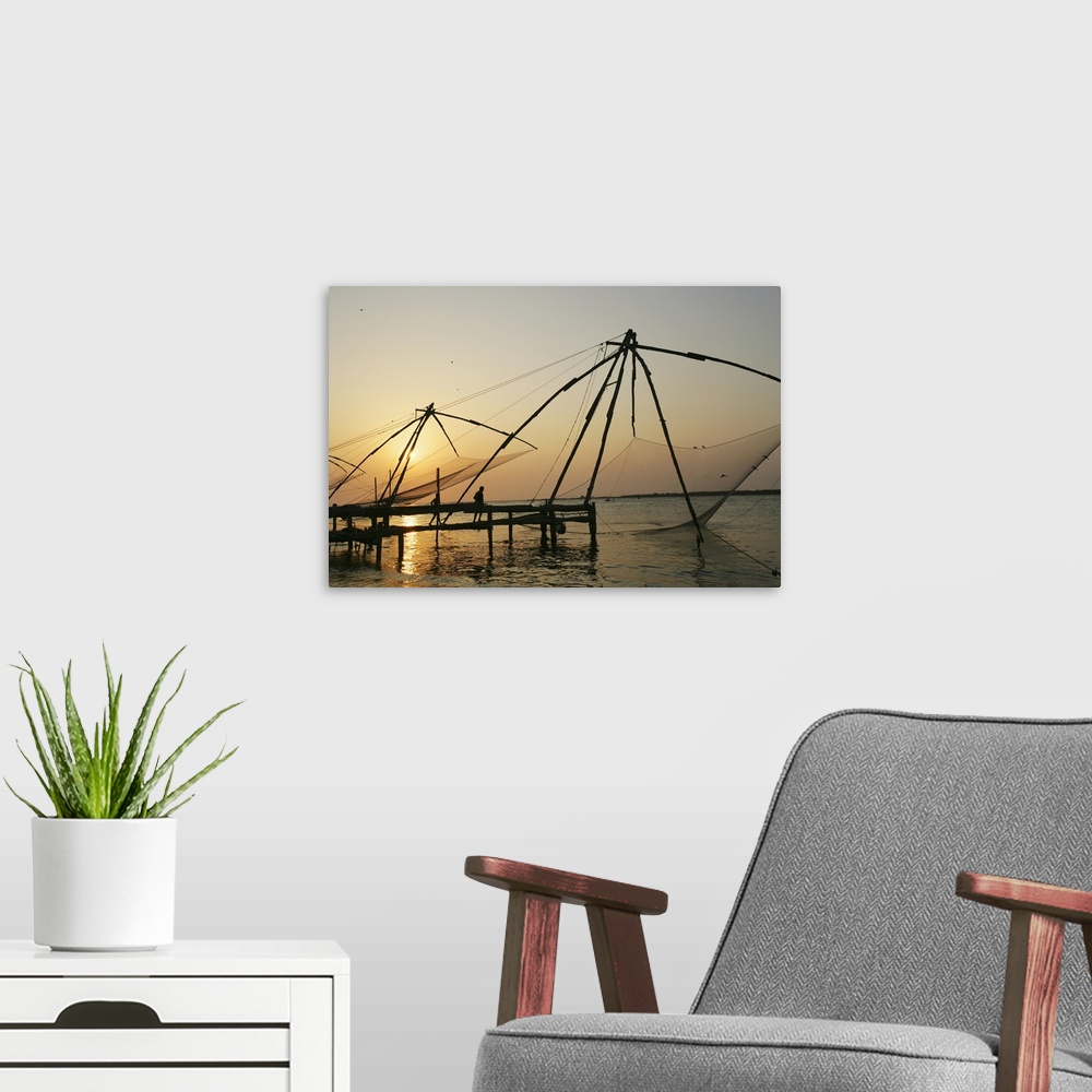 A modern room featuring Chinese Fishing Nets Hanging In The Water At Sunset, Fort Kochi