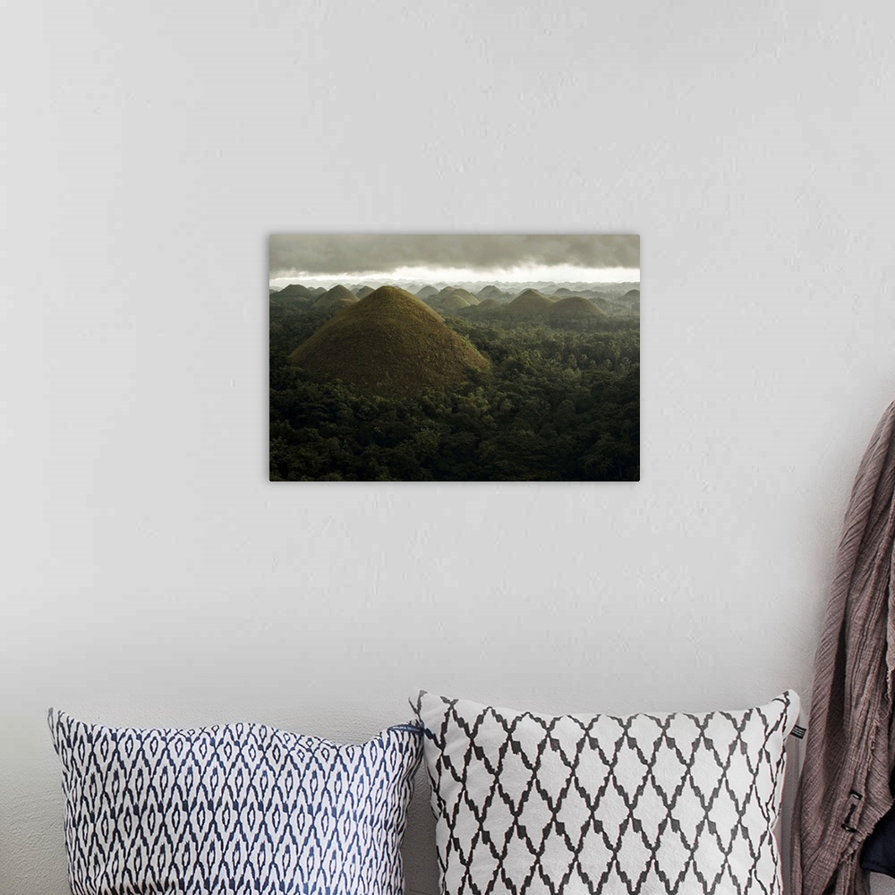 A bohemian room featuring Chocolate hills landscape from Bohol Island, a big storm covers the sky making an interesting lig...