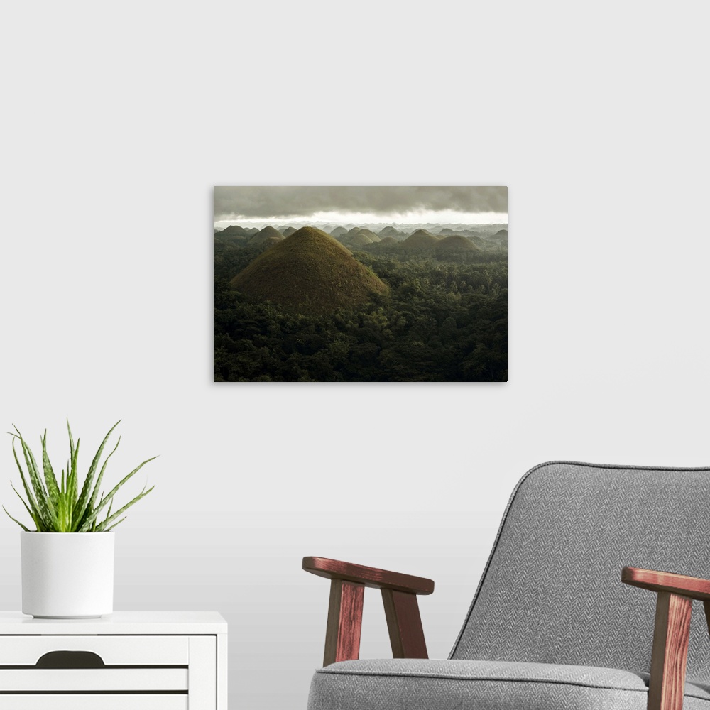 A modern room featuring Chocolate hills landscape from Bohol Island, a big storm covers the sky making an interesting lig...