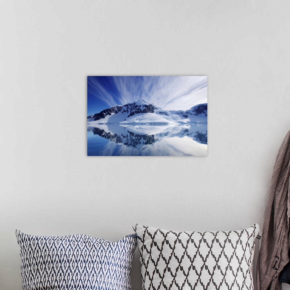 A bohemian room featuring Cirrus clouds over mountainous coast, and reflection in water.