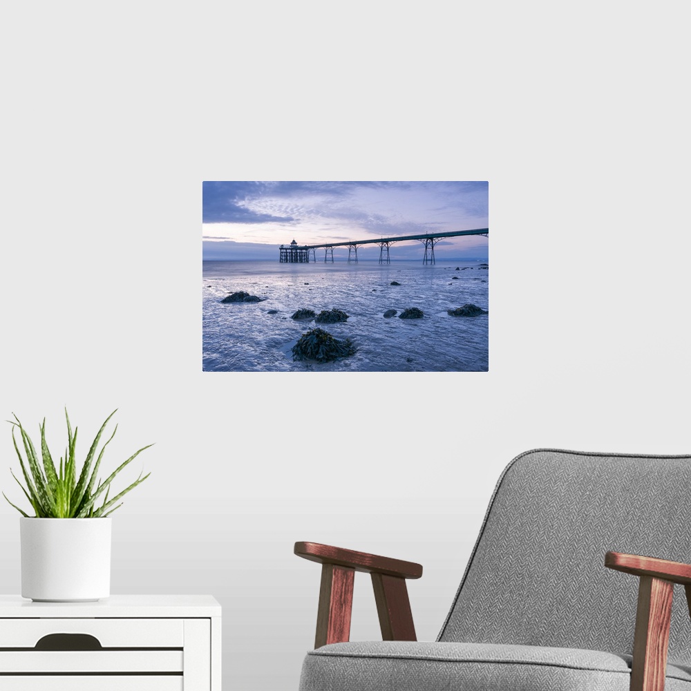 A modern room featuring Clevedon Pier in the Severn Estuary at low tide after sunset.
