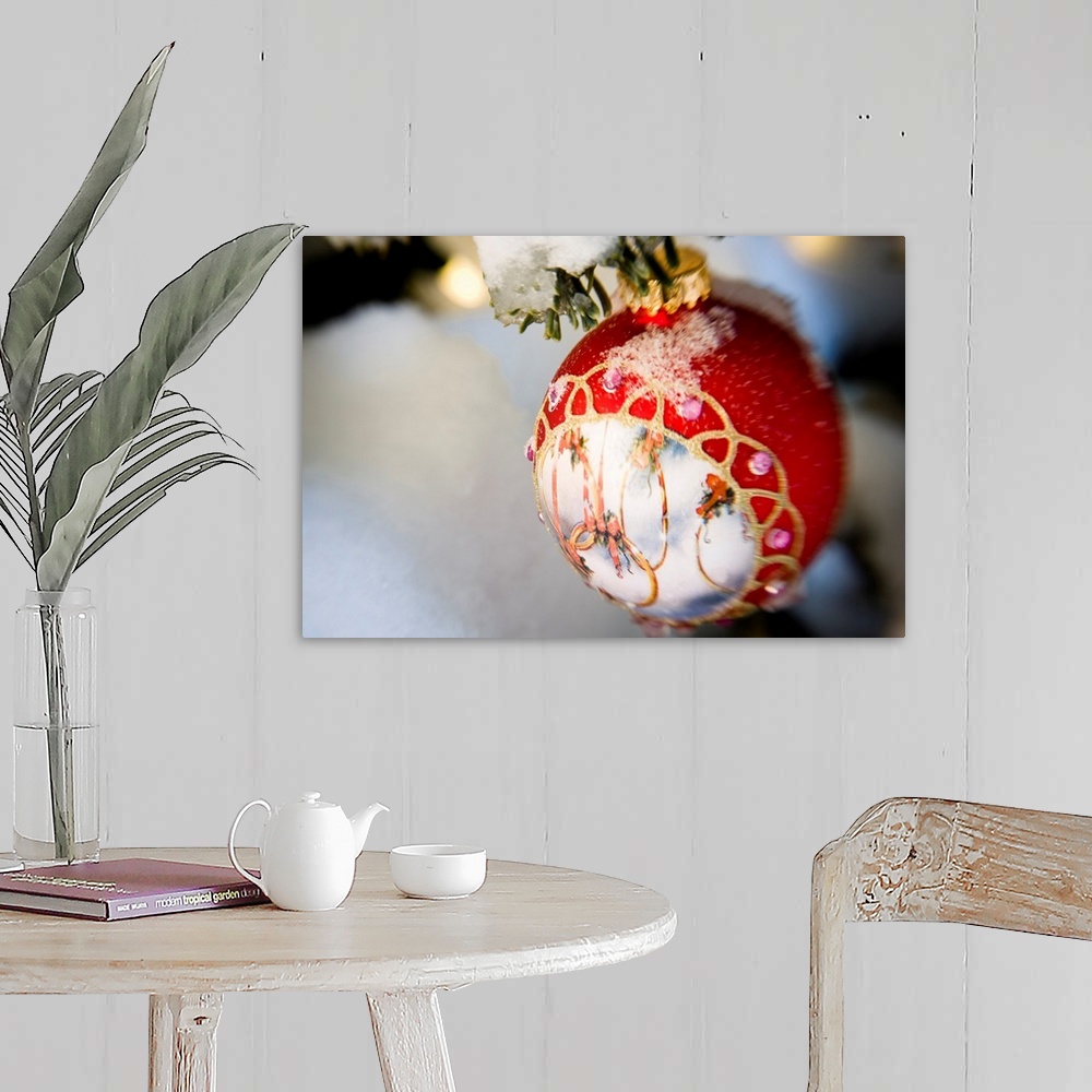 A farmhouse room featuring Close up of a Christmas ornament hanging on a snowcovered branch outdoors during winter