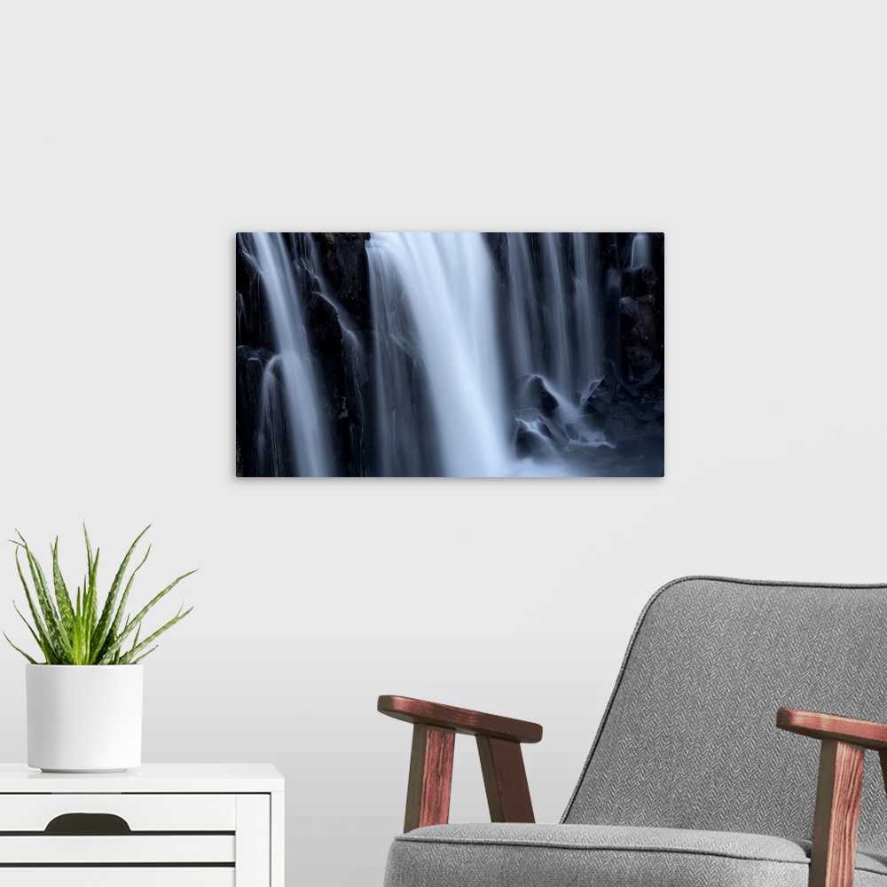 A modern room featuring Close-up of a series of waterfalls, the soft blur of flowing water over black rock, Iceland.
