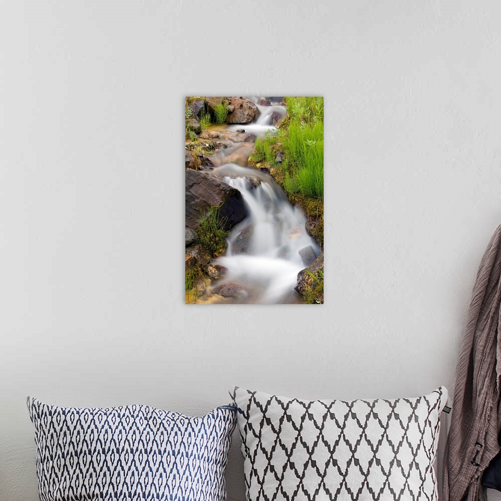 A bohemian room featuring Vertical canvas print of a stream washing down a hill through rocks.