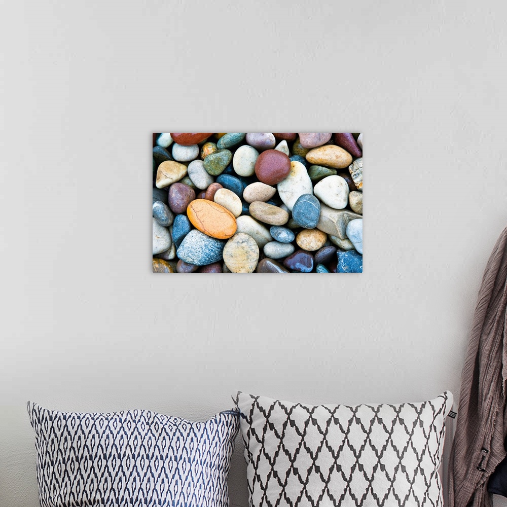 A bohemian room featuring A horizontal photograph of smooth river stones piled on a beach. This calming photograph would ma...