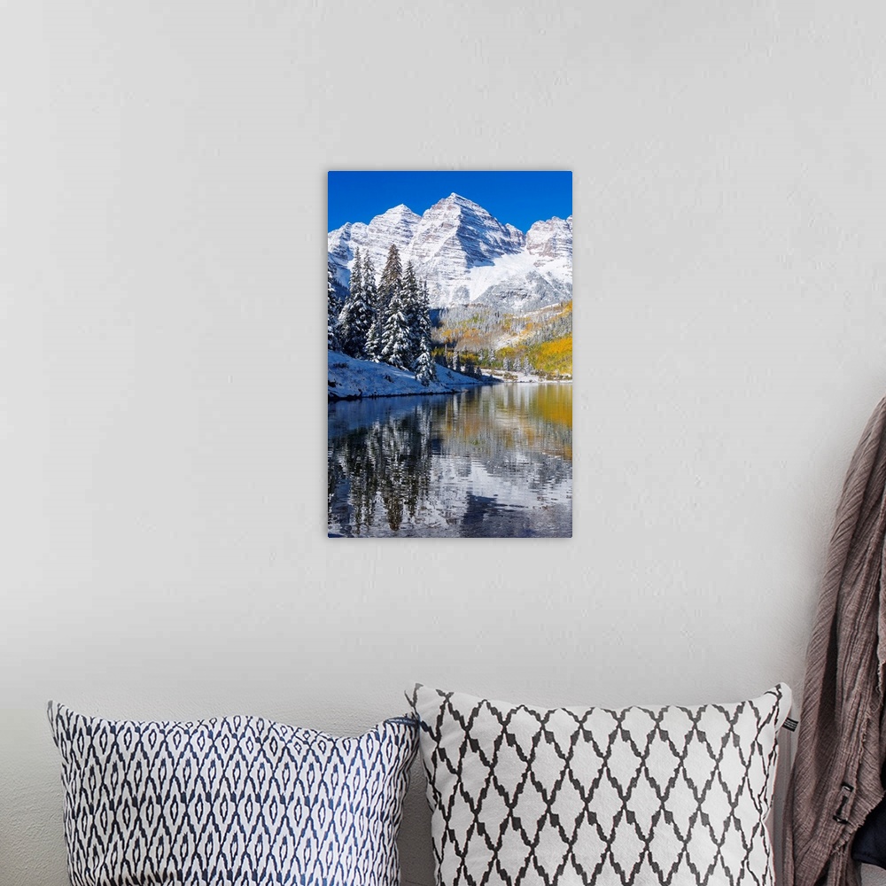 A bohemian room featuring Snow covered mountains are pictured against a clear blue background that reflects down in the bod...