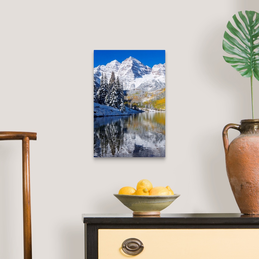 A traditional room featuring Snow covered mountains are pictured against a clear blue background that reflects down in the bod...
