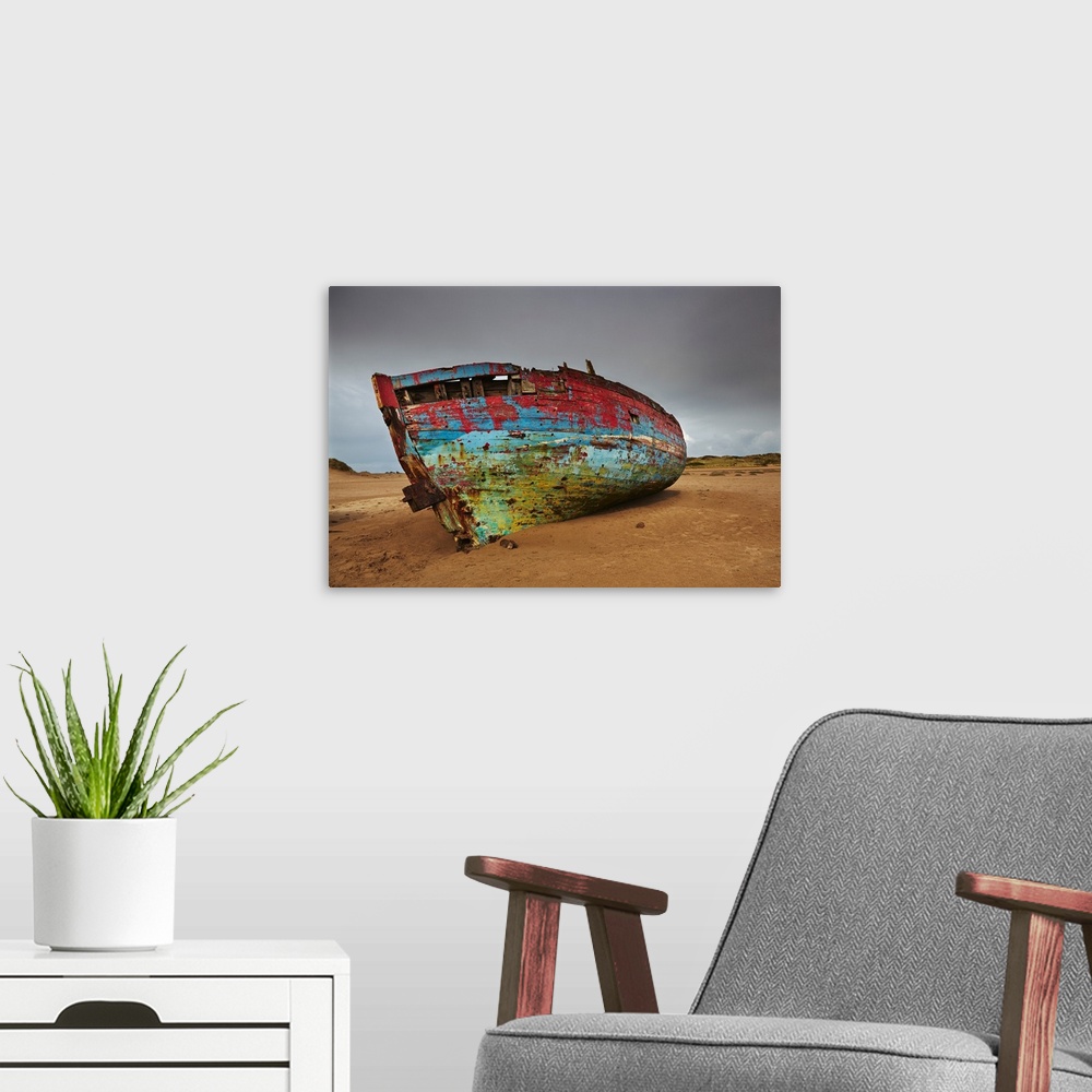 A modern room featuring Colourful weathered shipwreck lying in sand dunes at Crow Point, at the mouth of the Taw and Torr...