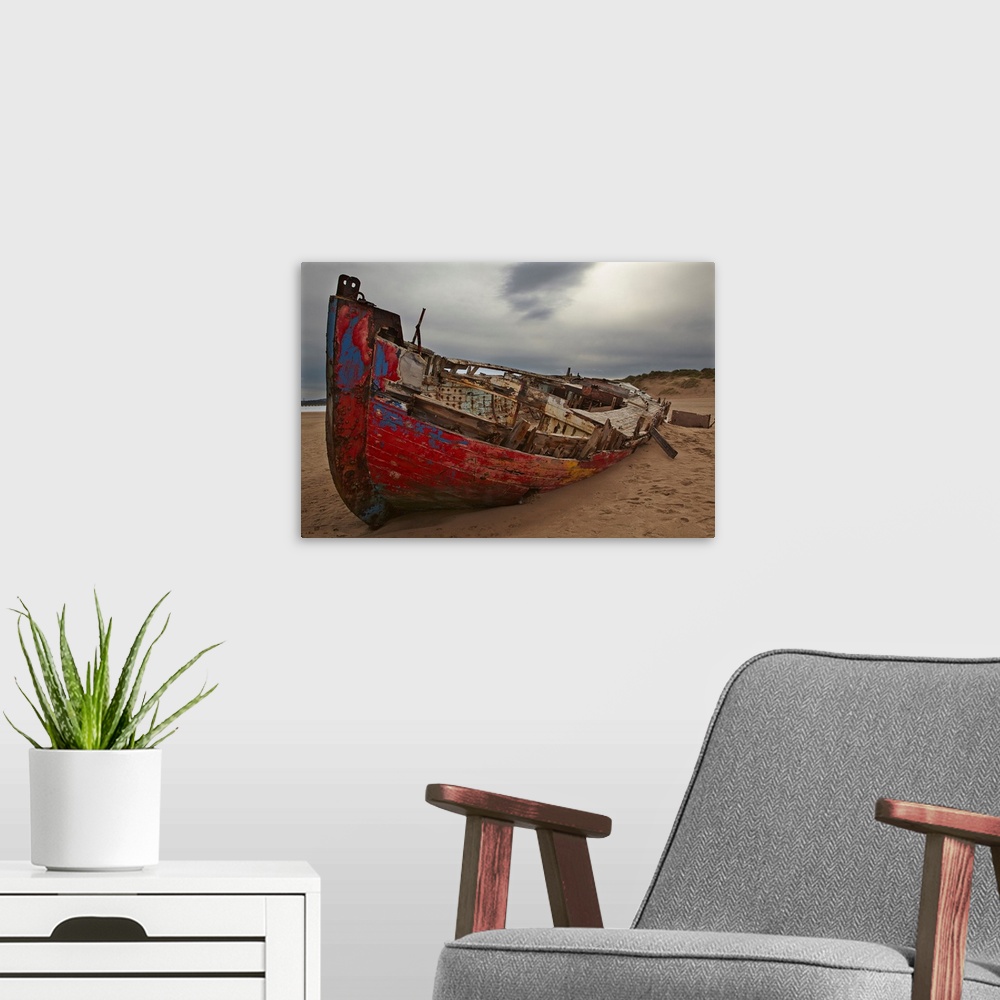 A modern room featuring Colourful weathered shipwreck lying in sand dunes at Crow Point, at the mouth of the Taw and Torr...