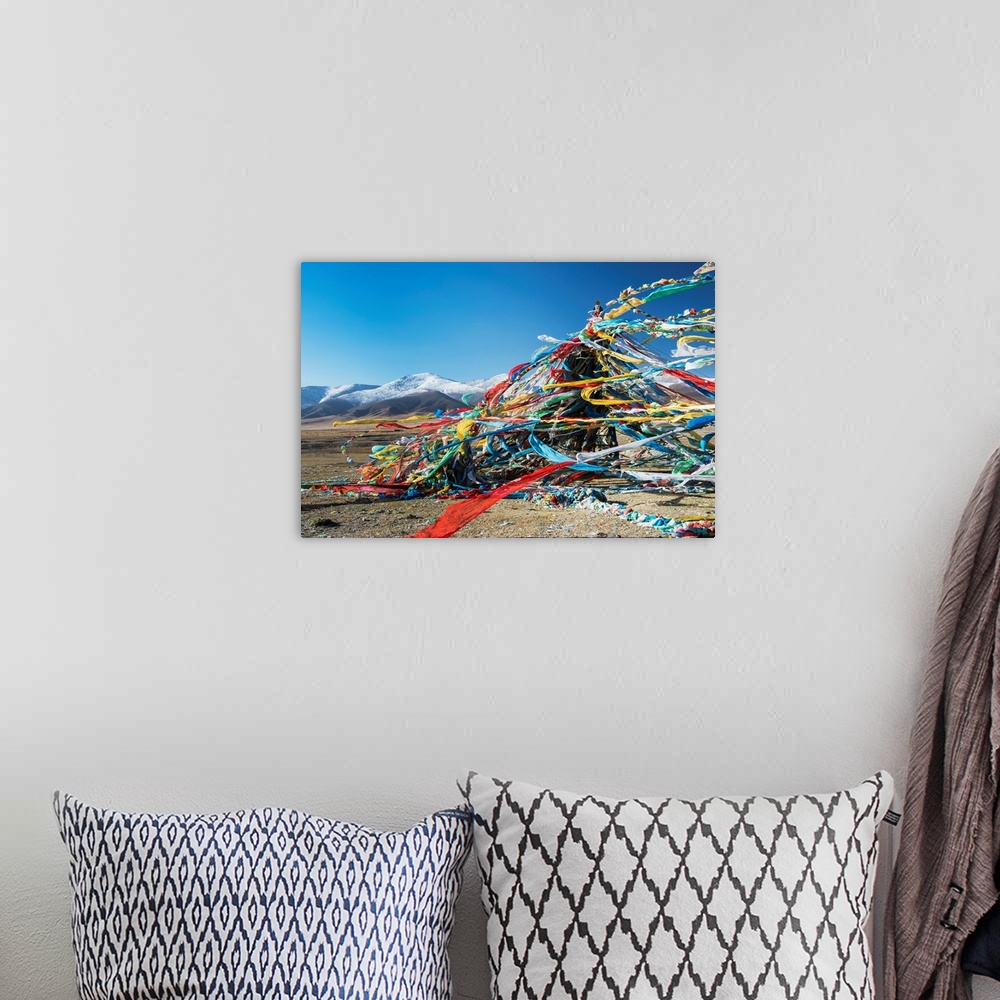 A bohemian room featuring Colourful Tibetan prayer flags (Lung ta) under the strong wind with white mountain tops in the ba...