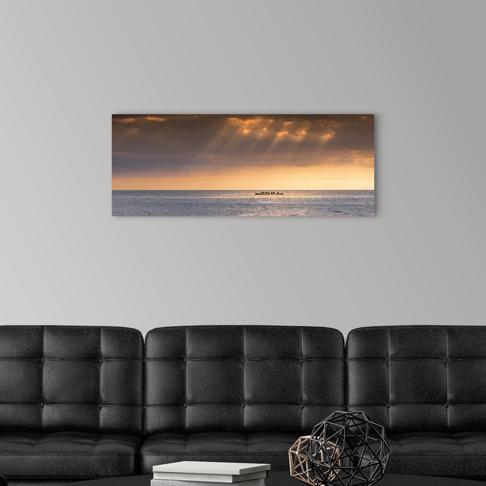 A modern room featuring A panoramic image of the 200 year old Cornish Pilot Gig Dove being rowed as the sun sets over Fis...