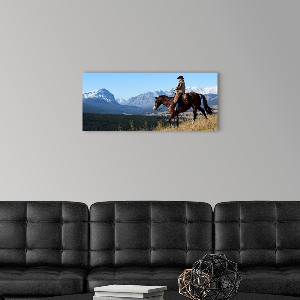 A modern room featuring Cowboy riding with a view of the Rocky mountains, Ya-Ha-Tinda Ranch, Clearwater County, Alberta, ...