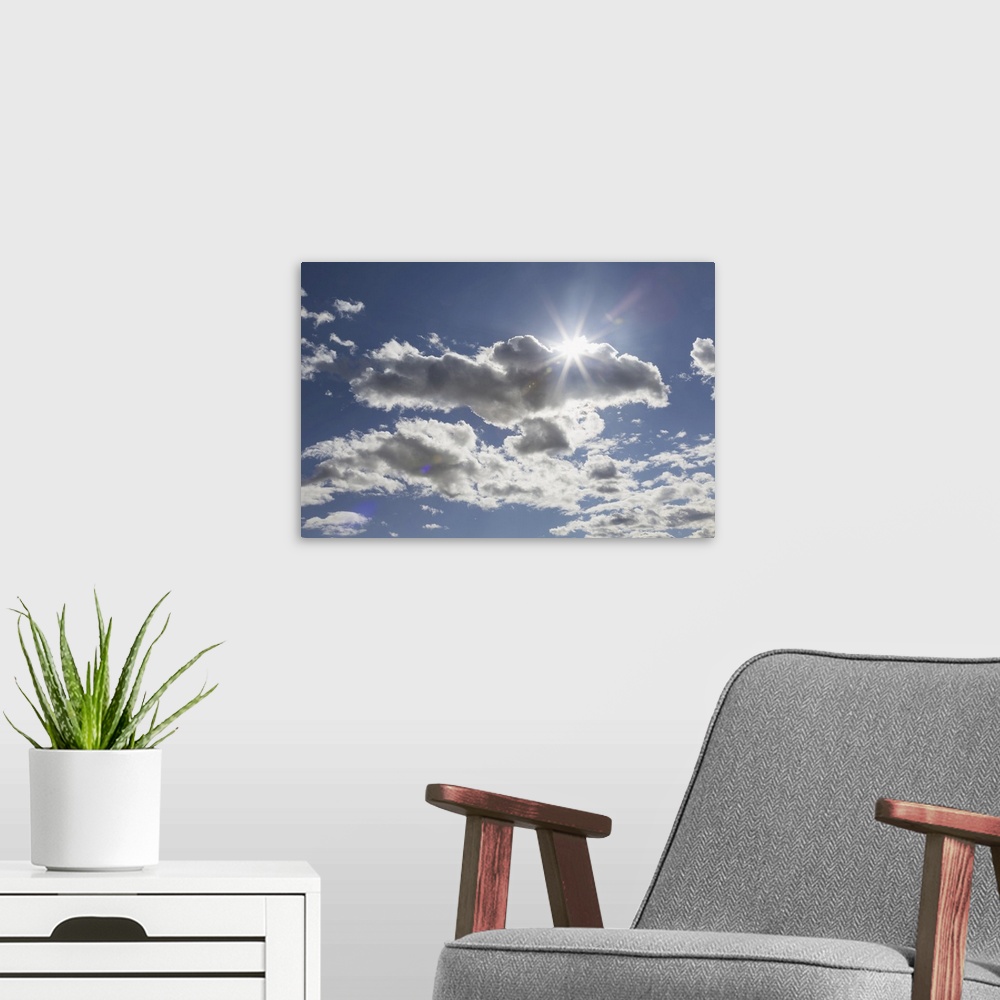 A modern room featuring Cumulus clouds in a blue sky with sunlight bursting from behind, Edmonton, Alberta, Canada.