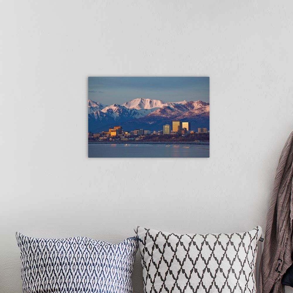 A bohemian room featuring Chugach mountain range seen behind a wide angle view of downtown Anchorage with mudflats in the f...