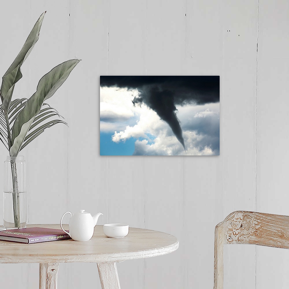 A farmhouse room featuring Dramatic funnel cloud created in dark storm clouds. Calgary, Alberta, Canada.