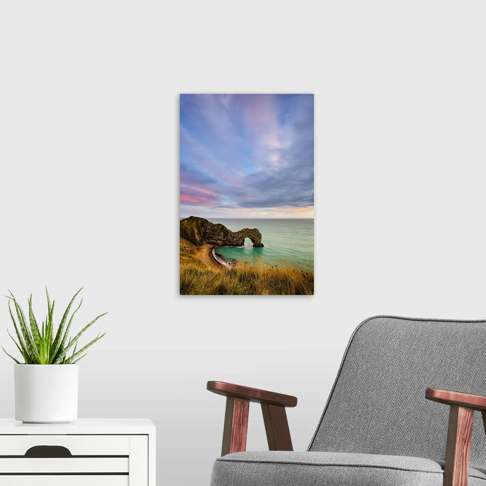 A modern room featuring Durdle Door at sunset.