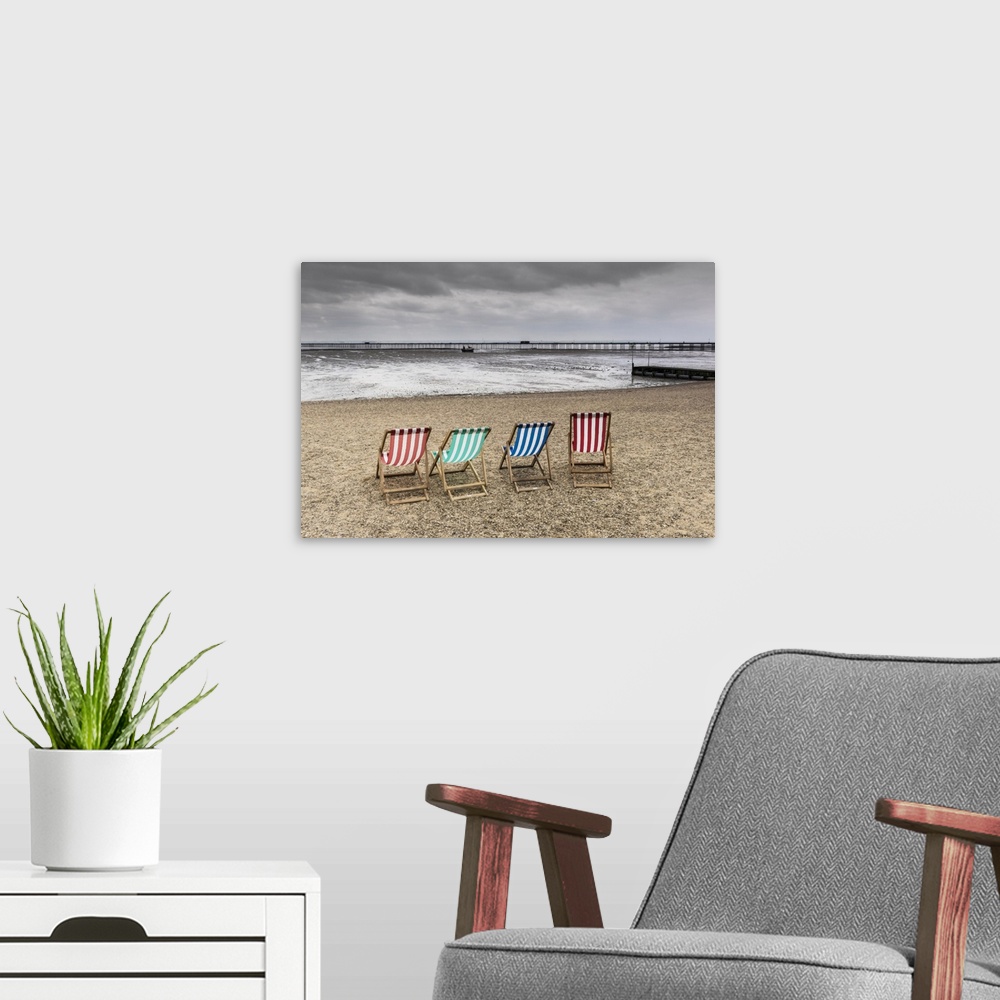 A modern room featuring Empty deckchairs on Jubilee Beach in Southend on a cloudy day.