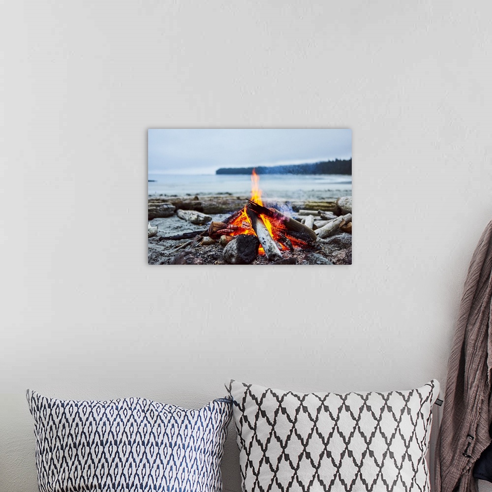 A bohemian room featuring A fire on the beach with the ocean and coastline in the background, Cape Scott Provincial Park; B...