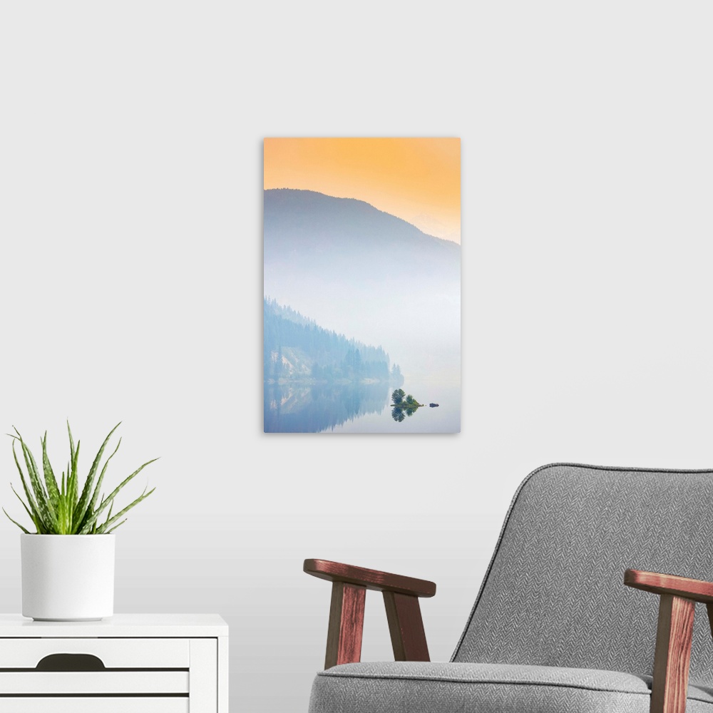 A modern room featuring Dense fog over a lake and mountain with a glowing orange sky at sunrise; British Columbia, Canada