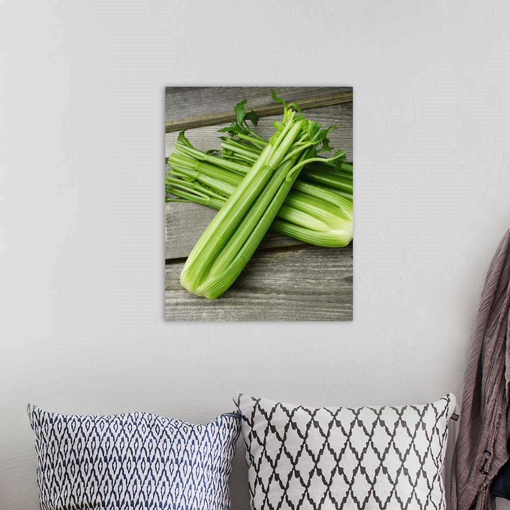 A bohemian room featuring Fresh heads of celery, on a barnwood surface