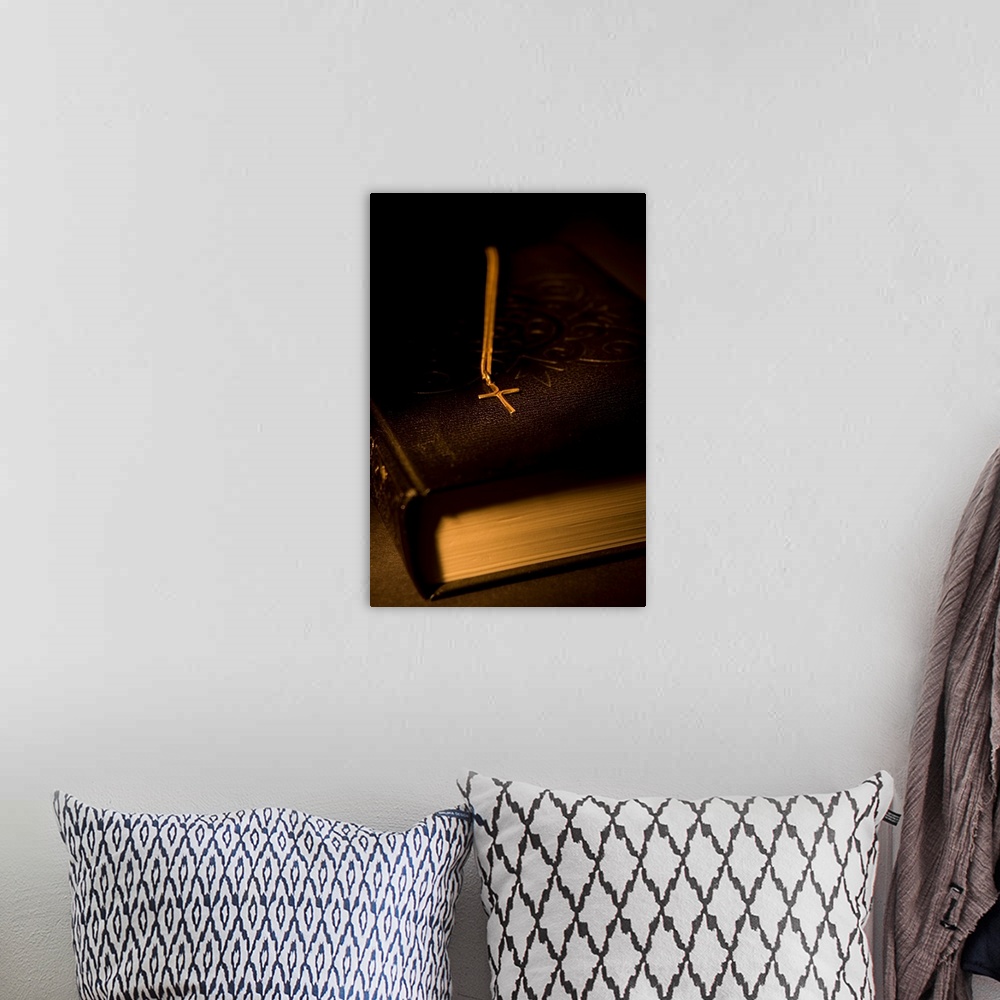 A bohemian room featuring Gold Cross Pendant Resting On A Book