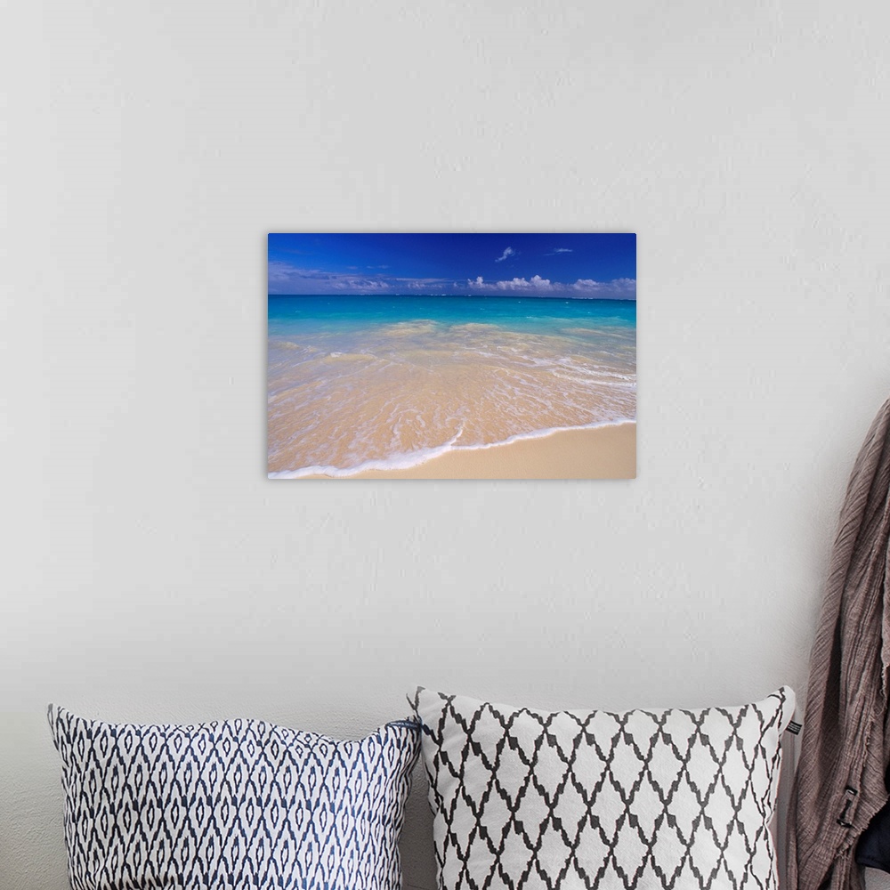 A bohemian room featuring Wall docor of clear ocean water washing ashore a white sanded beach.