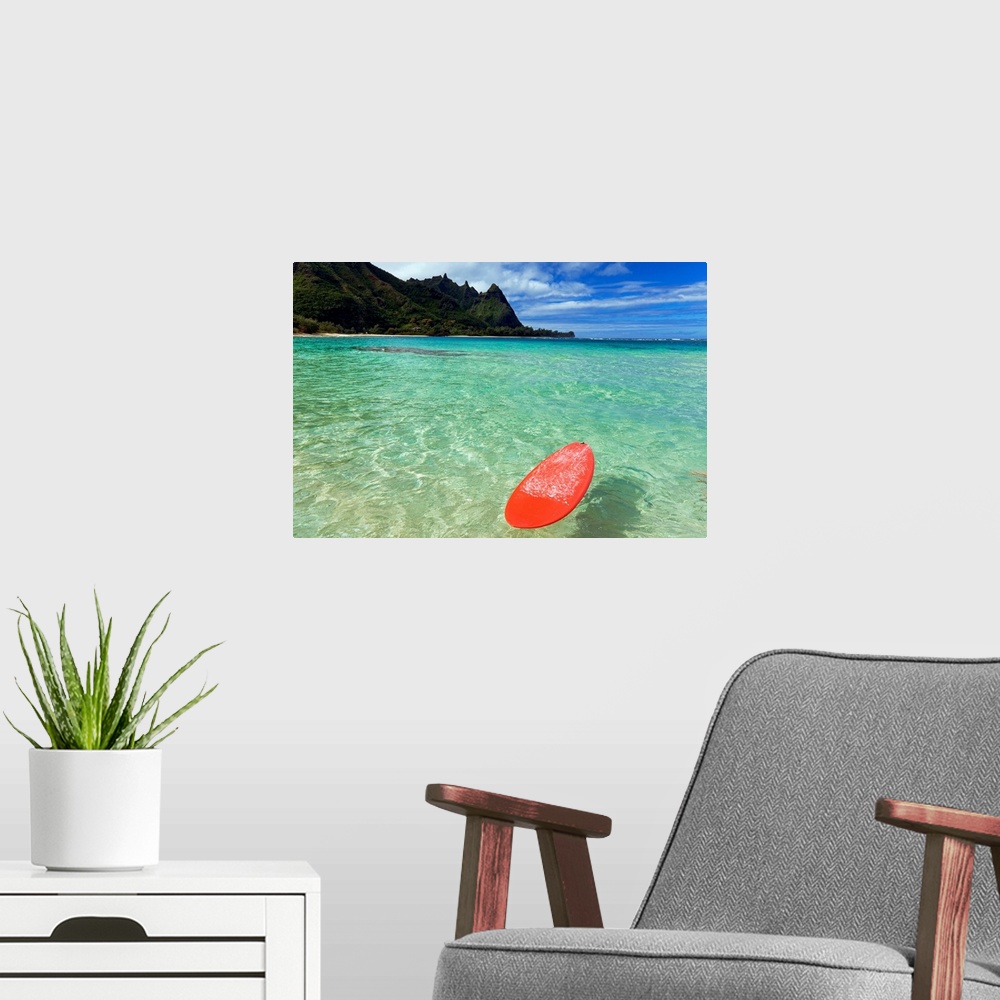 A modern room featuring Photograph of bobbing surfboard in ocean with crystal clear waters and a small beach with tree co...