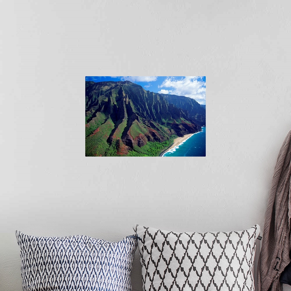 A bohemian room featuring This large piece is an aerial photograph of huge mountains on the coast of a Hawaiian island.