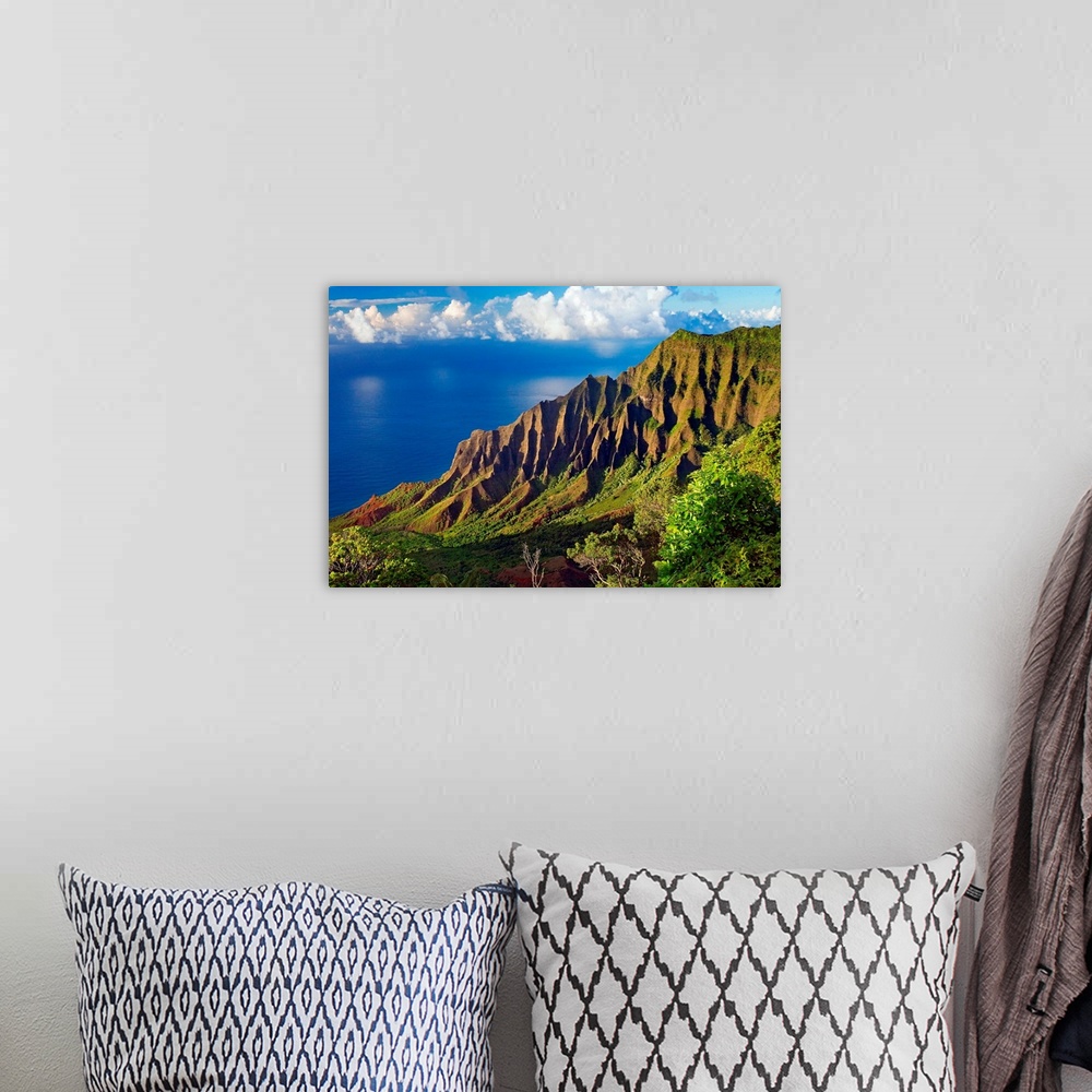 A bohemian room featuring This is a landscape photograph of mountain cliffs on a view down a hillside to the ocean and cumu...