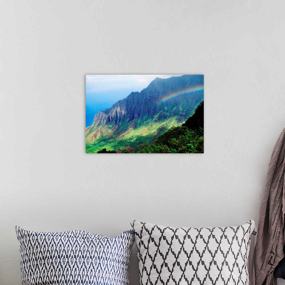 A bohemian room featuring Large canvas photo art of a rainbow in the middle of lush Hawaiian mountains.