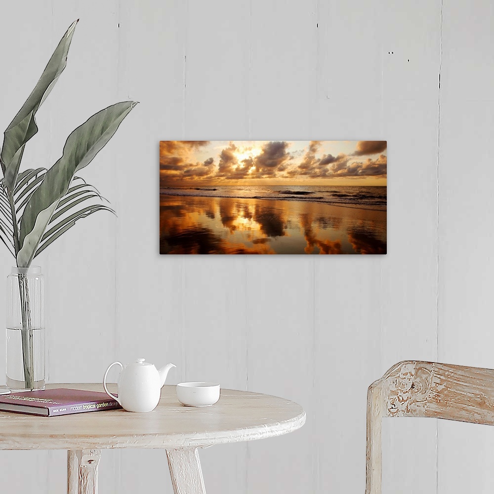 A farmhouse room featuring Panoramic photograph of seashore at dusk.  There is standing water on the beach and waves rolling...