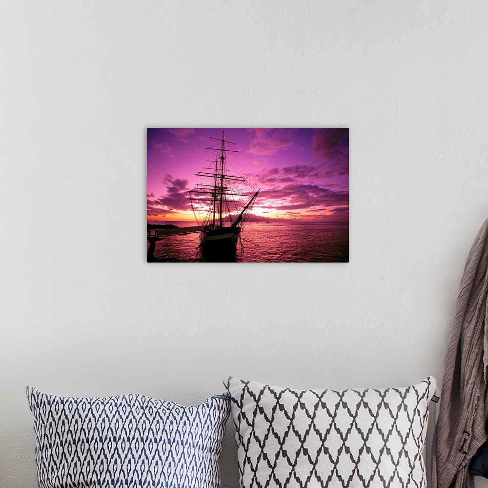 A bohemian room featuring Landscape photograph of a silhouetted Carthaginian ship in the waters of Lahaina Harbor, beneath ...