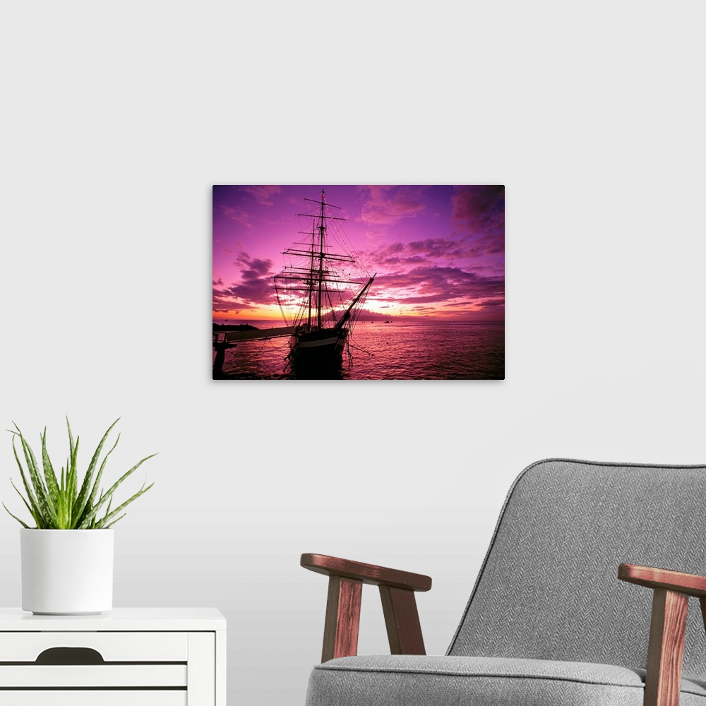 A modern room featuring Landscape photograph of a silhouetted Carthaginian ship in the waters of Lahaina Harbor, beneath ...