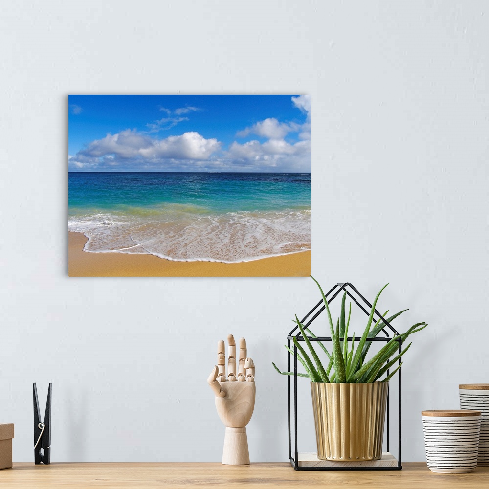 A bohemian room featuring Photograph of ocean washing up onto beach creating sea foam under a cloudy sky.