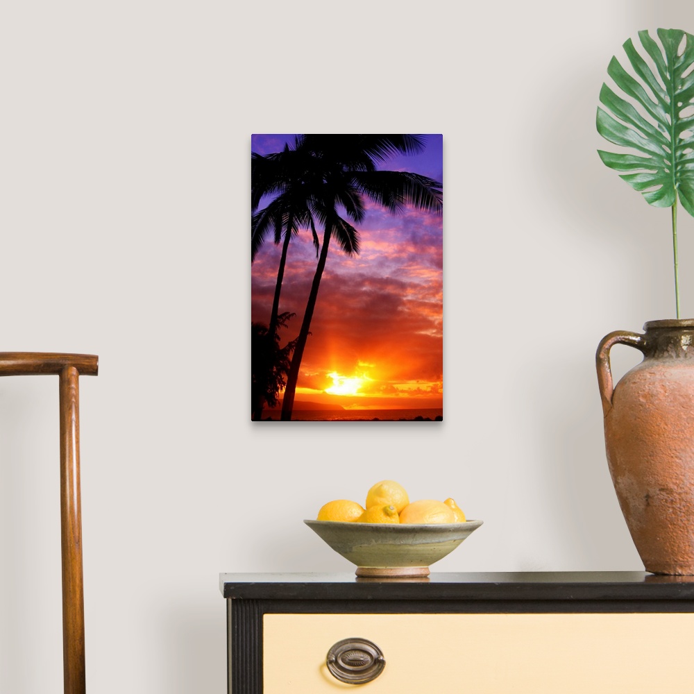 A traditional room featuring Tall wall docor of silhouetted palm trees against a colorful sunset.