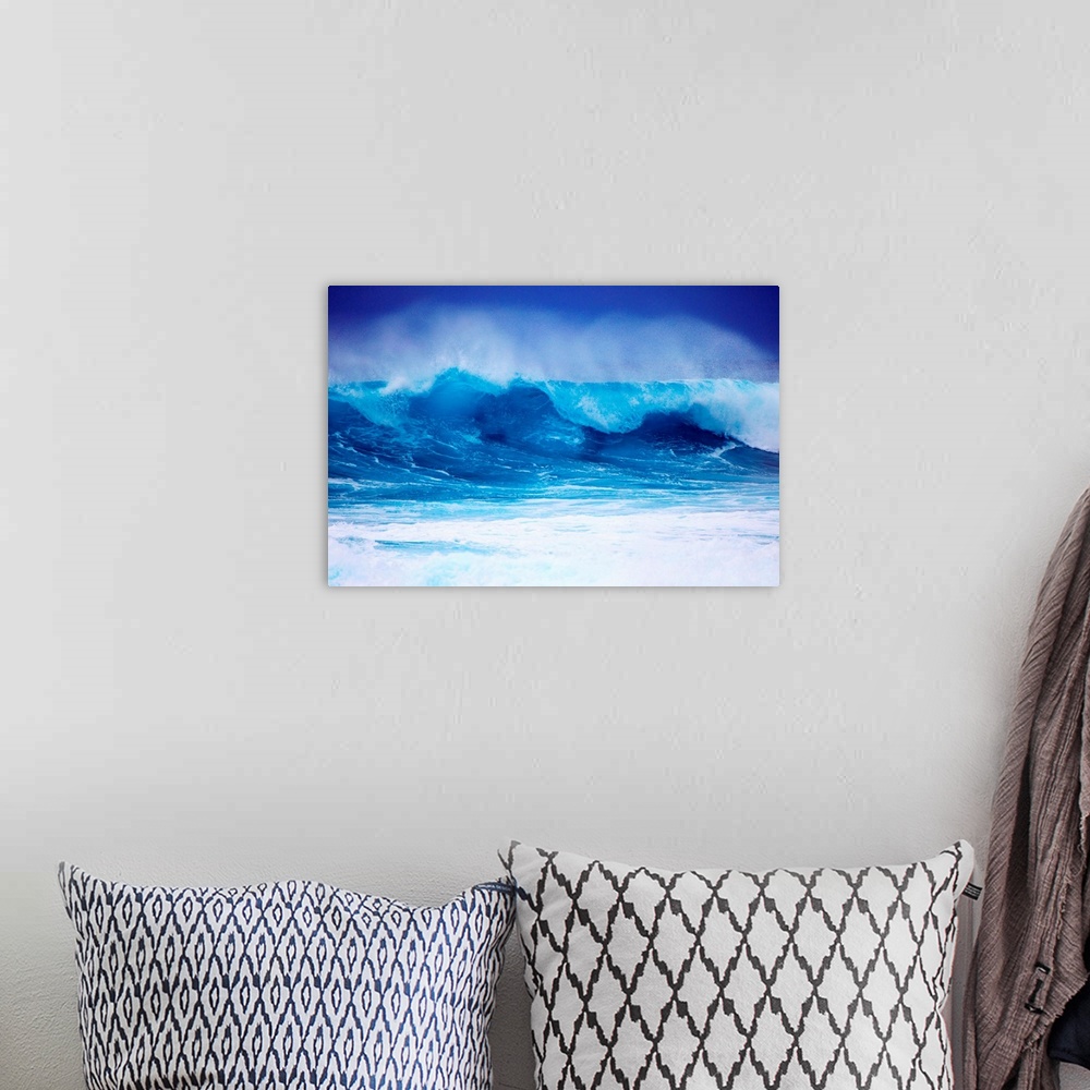A bohemian room featuring Giant horizontal photograph of a vibrant blue wave spraying upward as it begins to crash onto its...