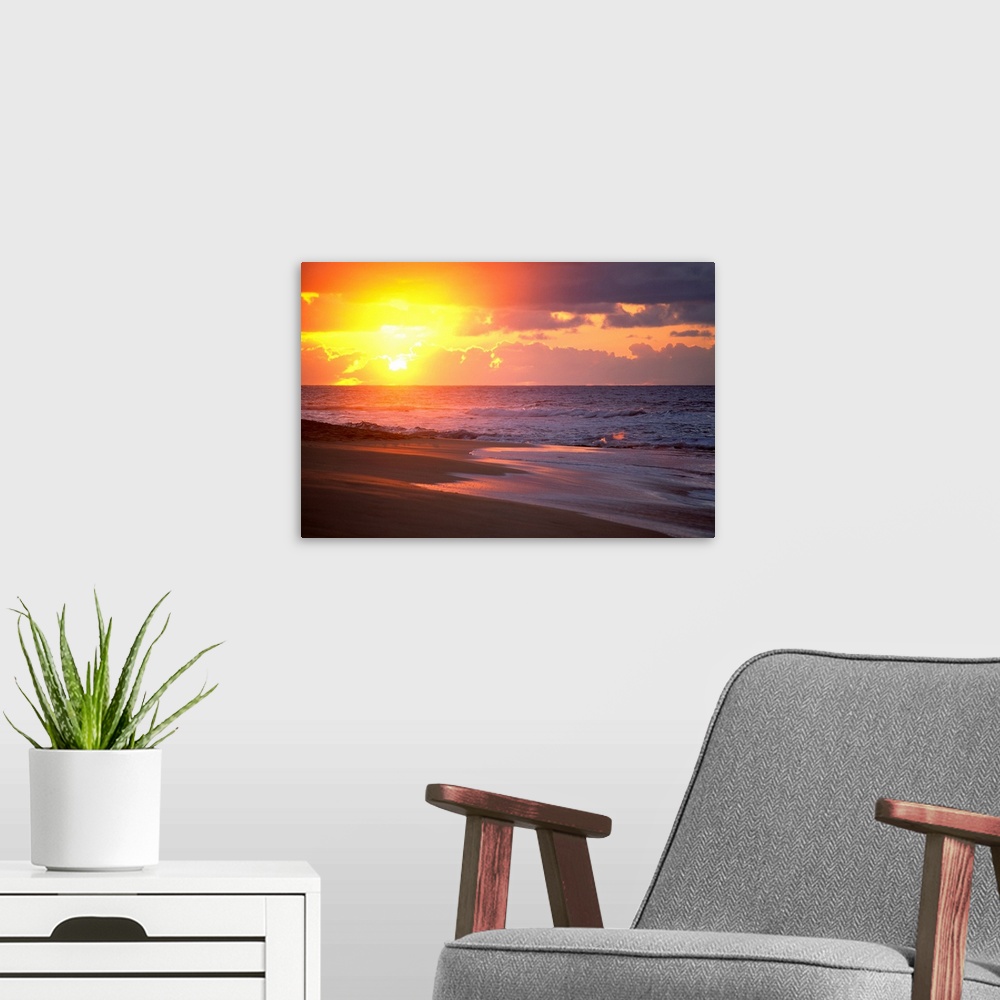 A modern room featuring Big canvas print of waves crashing on to a beach with the sun rising in the background.