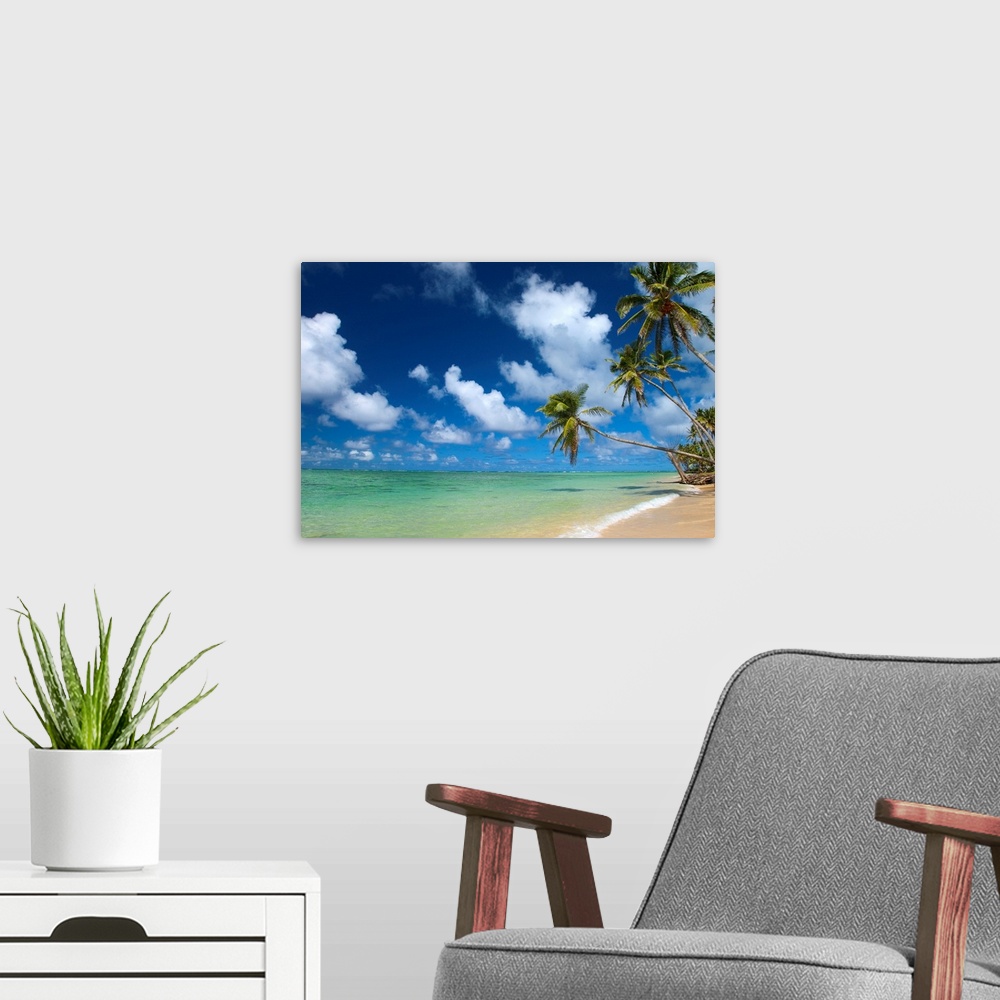 A modern room featuring Serene scene of a sandy beach and clear tropical ocean water under a sky filled with clouds.
