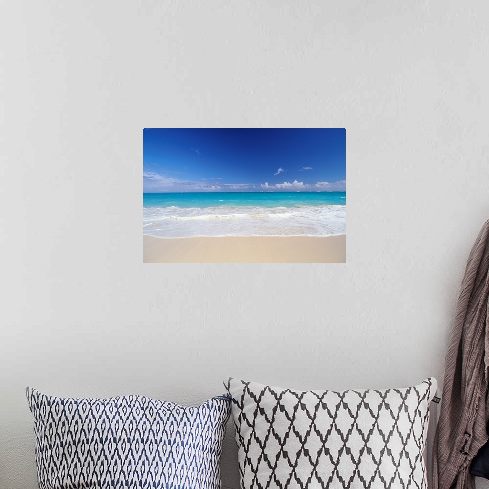 A bohemian room featuring Horizontal photograph on a big canvas of bright turquoise ocean water, crashing into the sand on ...